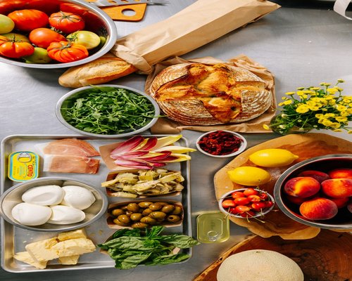 A variety of fresh, local and whole foods laid out cleanly on a family kitchen dining layout table
